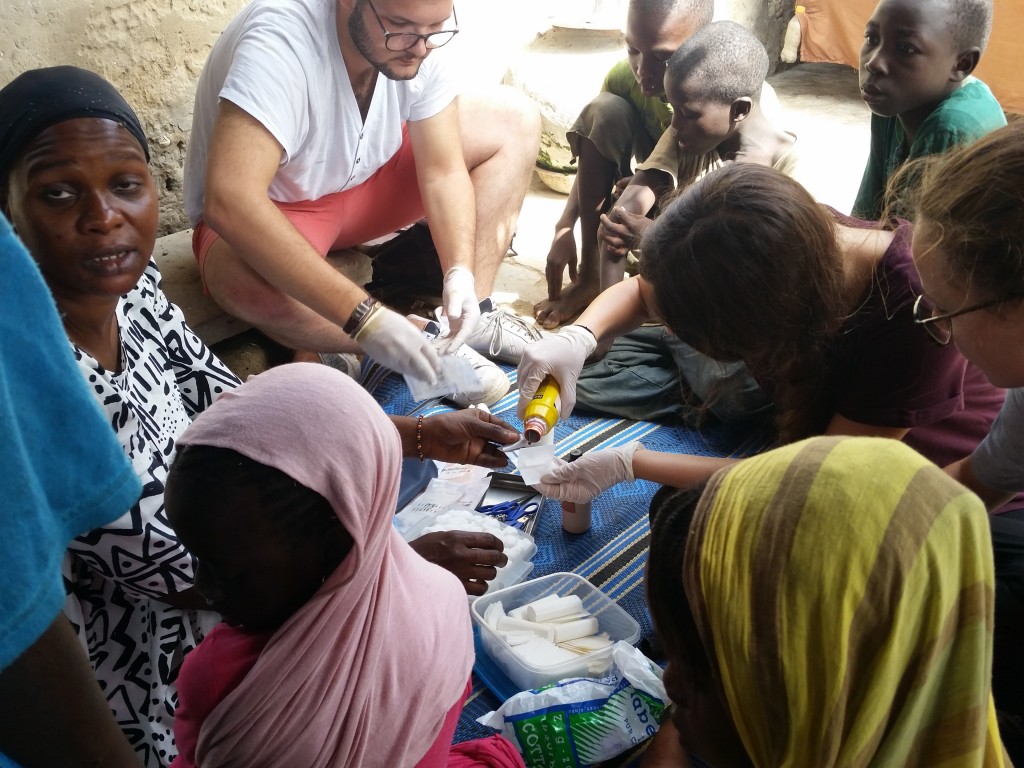 Pardonnez le visage d'Amina mais ici les volontaires font le soin au daara/Excuse Amina's face but here the volunteers are disinfecting sores of the children in the daara