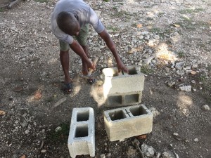 Our incredible grounds keeper, Jean Claude, helps me prepare blocks to make a rocket stove that burns fuel more efficiently