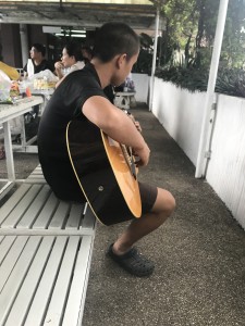 Hong playing guitar on an excursion to the pool.