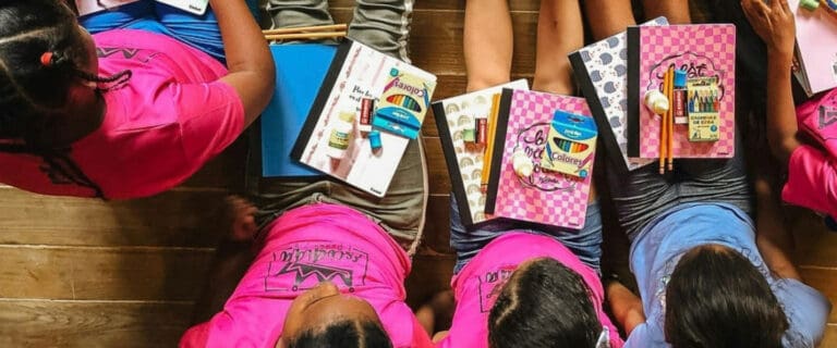 Children sitting with school supplies