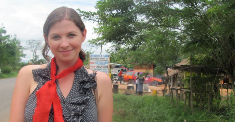 Person wearing red scarf and smiling.